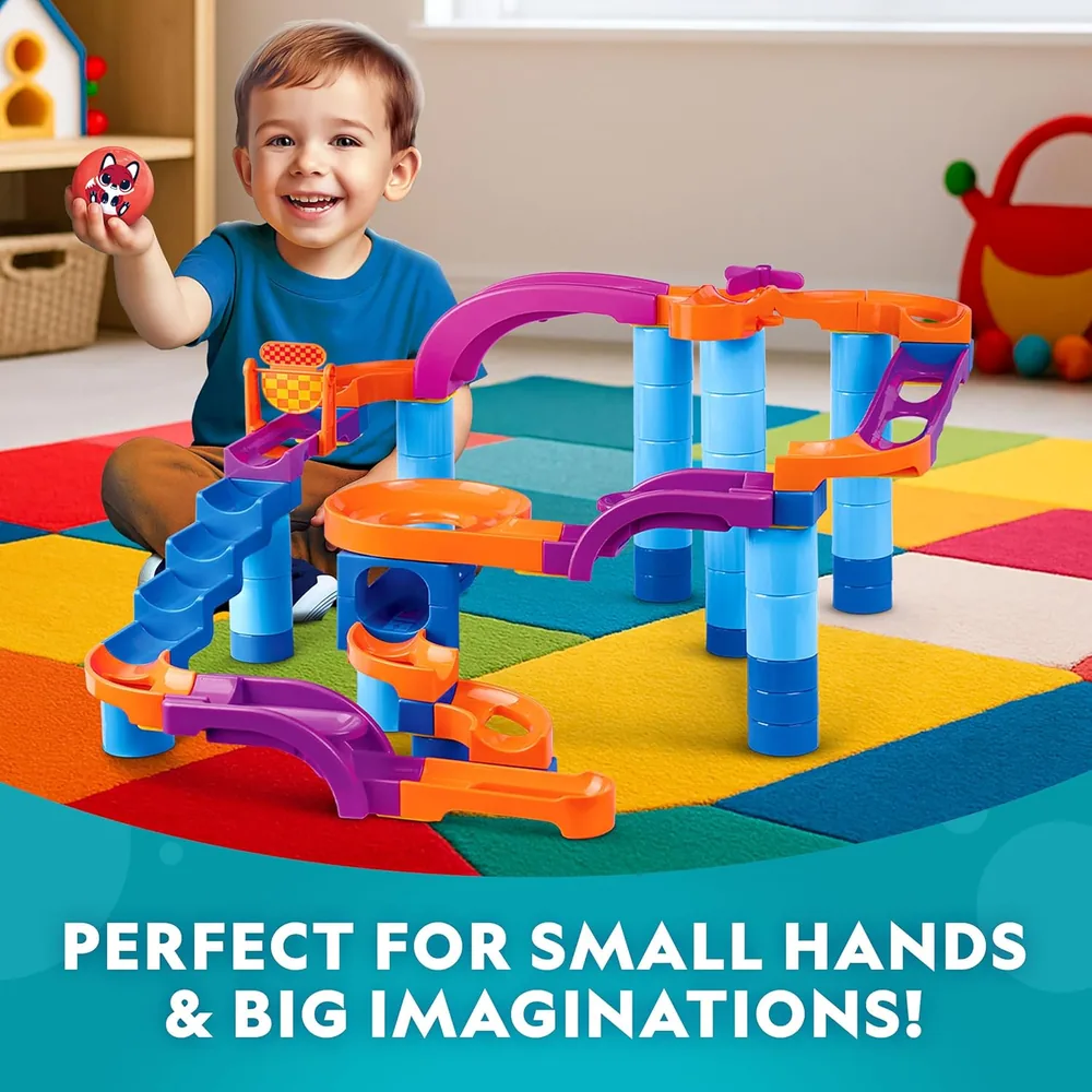 Toddler playing with the ball drop tower on a colorful play mat